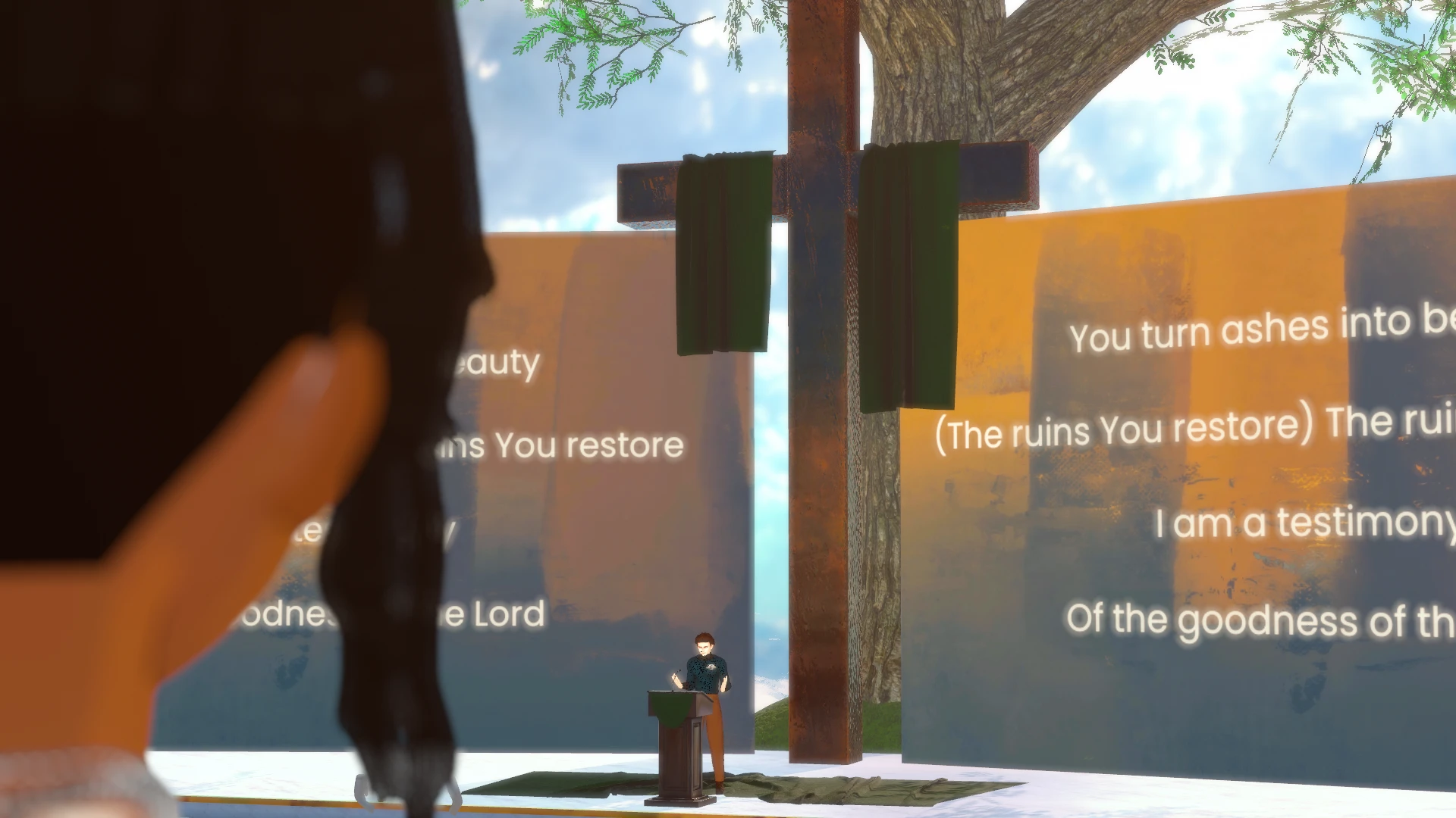 Looking over an attendee's shoulder toward Pastor Mike's avatar at the podium, a tall wooden cross with a green drape, and worship lyrics on the screens.